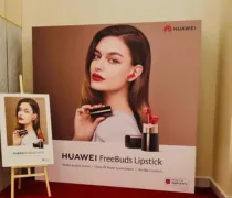 A stylish model showcases Huawei FreeBuds Lipstick, holding a product with a modern design against a neutral backdrop