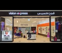 A storefront labeled 'Vision Express' features an array of eyewear displays. Brightly lit with a modern interior design