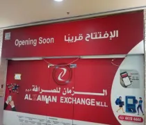 Red storefront with the text Opening Soon and 'AL ZAMAN EXCHANGE W.L.L.' displayed in Arabic and English