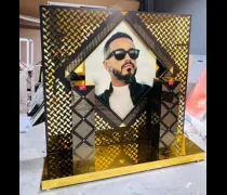 A decorative display features a portrait in a diamond-shaped frame, surrounded by a gold and black patterned backdrop