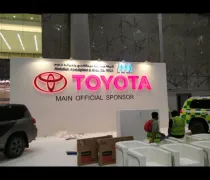 A setup for an event shows a large 'TOYOTA' sign surrounded by workers and vehicles