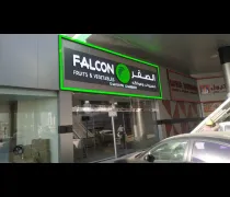 A storefront for  Falcon Fruits & Vegetables,  featuring a large sign in both English and Arabic with a green leaf icon