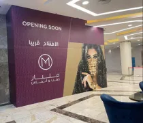 A vibrant wall mural announces  Opening Soon  in Arabic and English, featuring an elegantly adorned woman