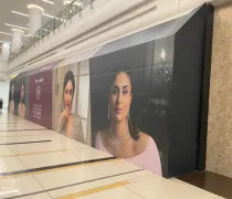 A long wall mural features portraits of two elegant women, showcasing fashion and style. Bright, modern indoor setting